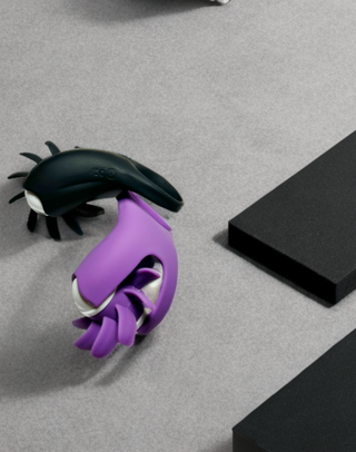 Black and purple couples ring with tongue-shaped teaser on gray background with black blocks.