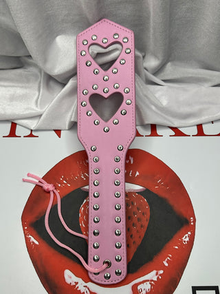 Side profile of pink Love Taps paddle revealing ergonomic handle shape.