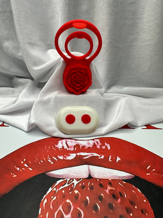 Rose Grip dual ring vibrator standing upright with matching remote beside it on silky backdrop.